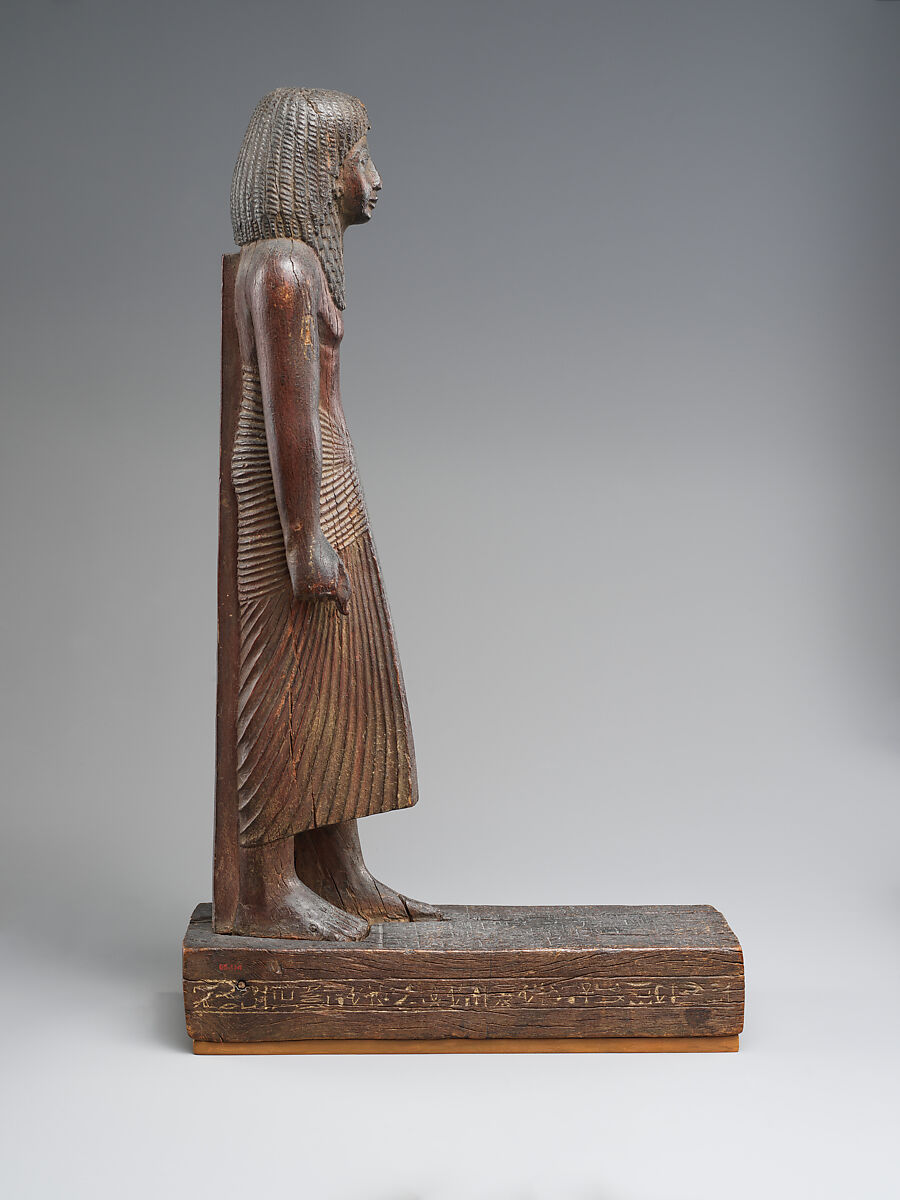 Statuette of Kary carrying a standard of Horus, Wood
