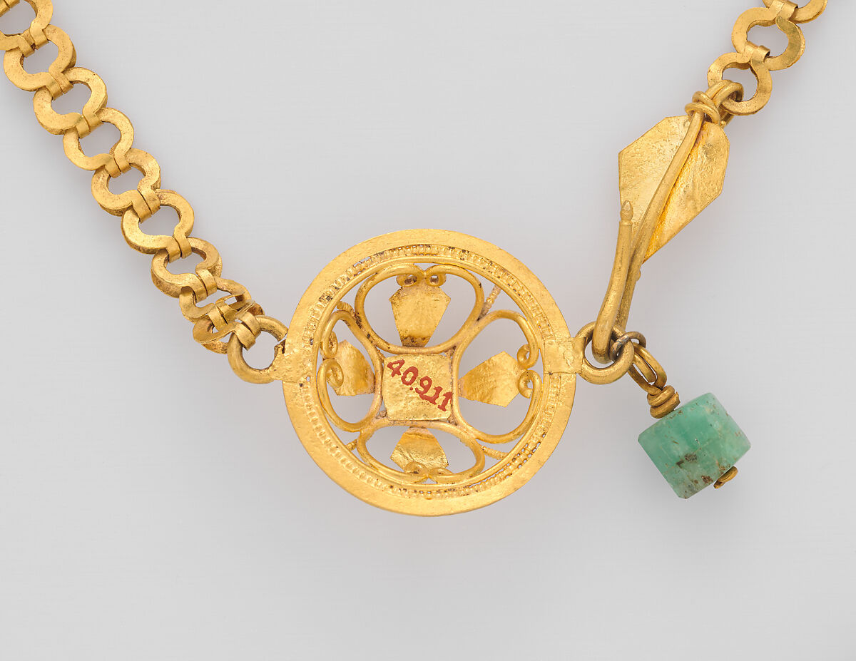 Chain terminating in a leaf motif, and having a raised openwork clasp ornament, gold, blue stone, emerald