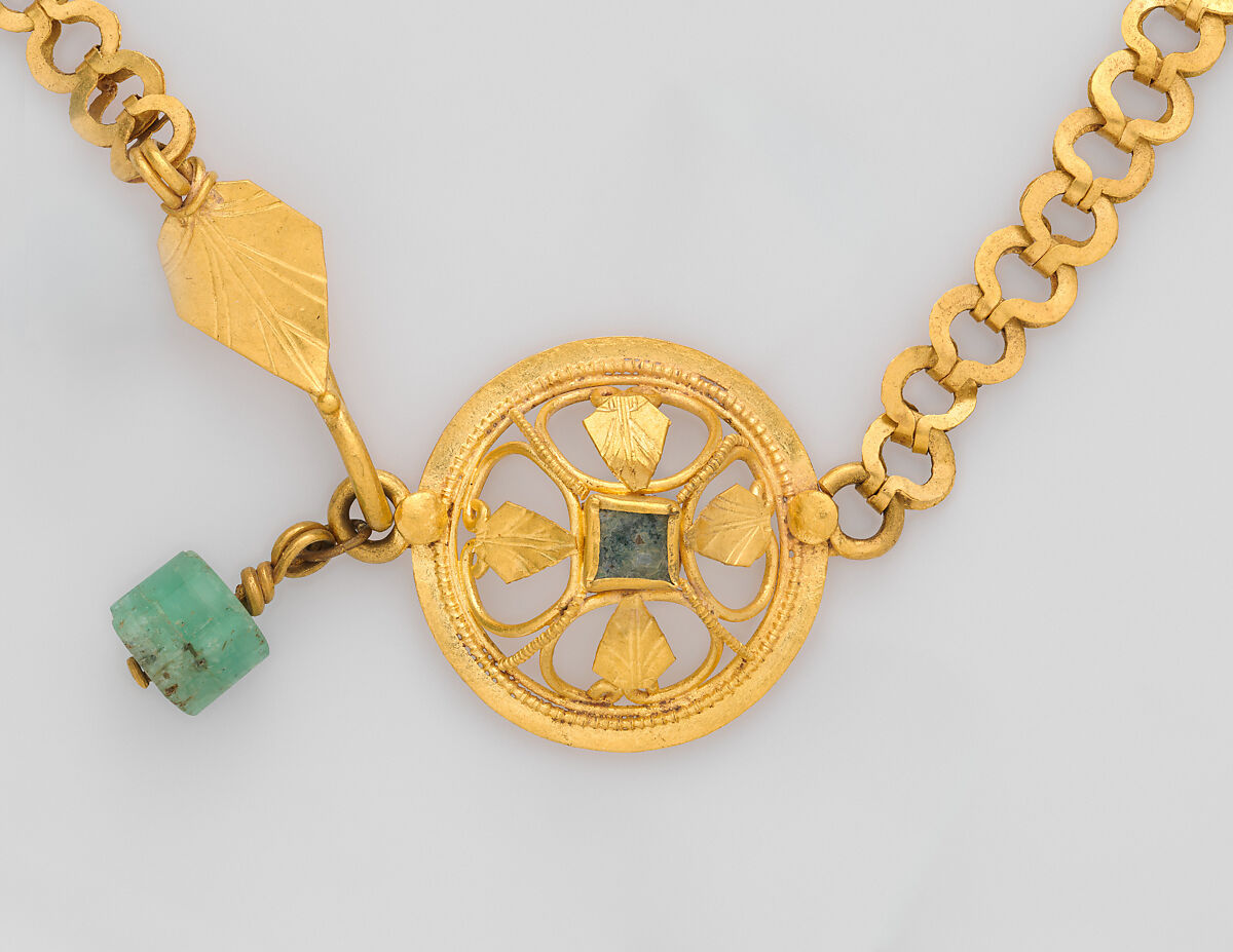 Chain terminating in a leaf motif, and having a raised openwork clasp ornament, gold, blue stone, emerald