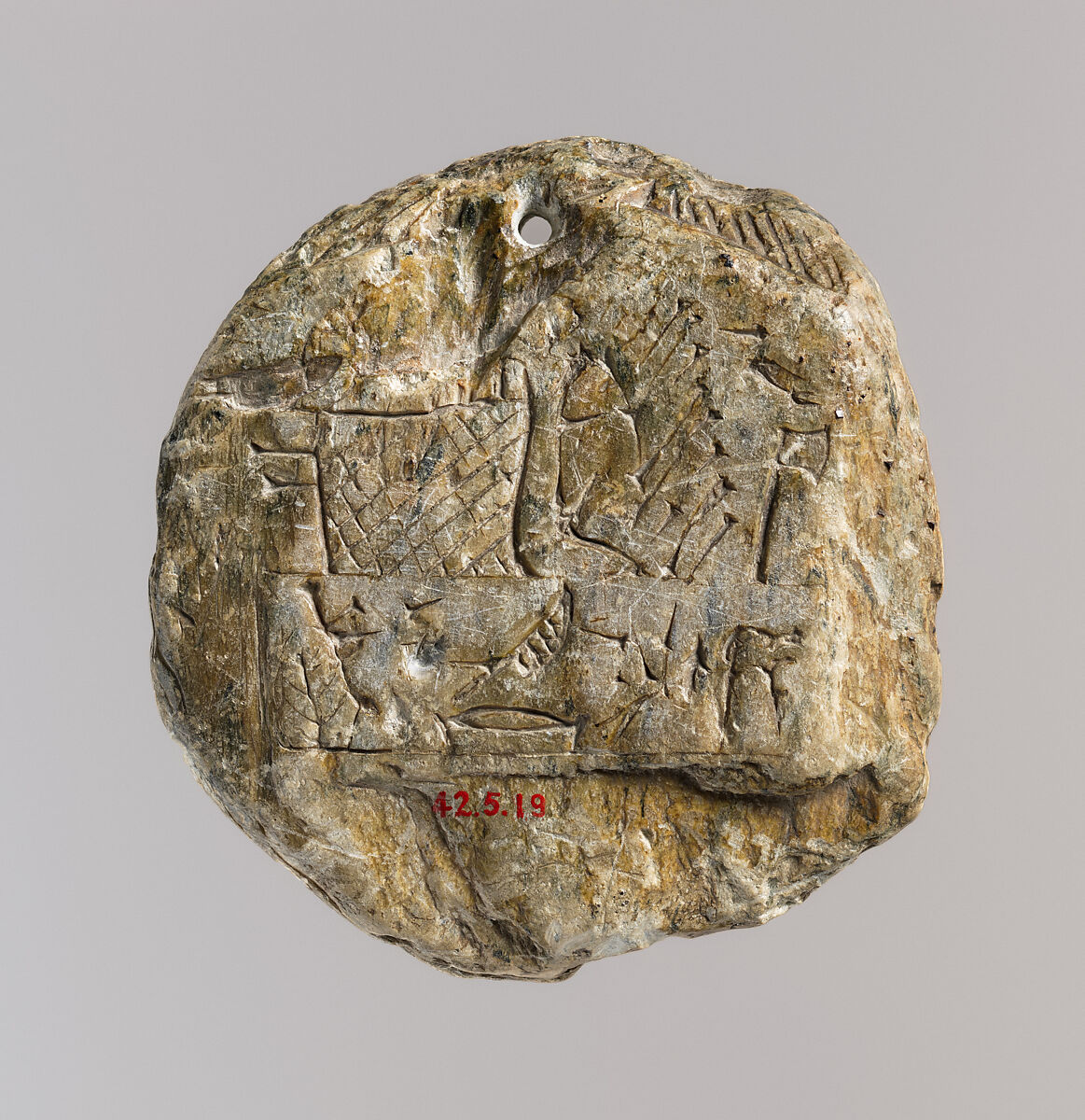 Bes head disk with scene of Isis and Horus in marsh on reverse, Steatite