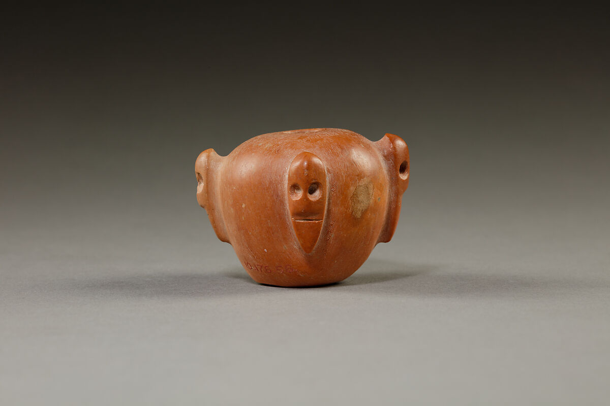 Piriform macehead with male faces, Limestone (pink), organic material