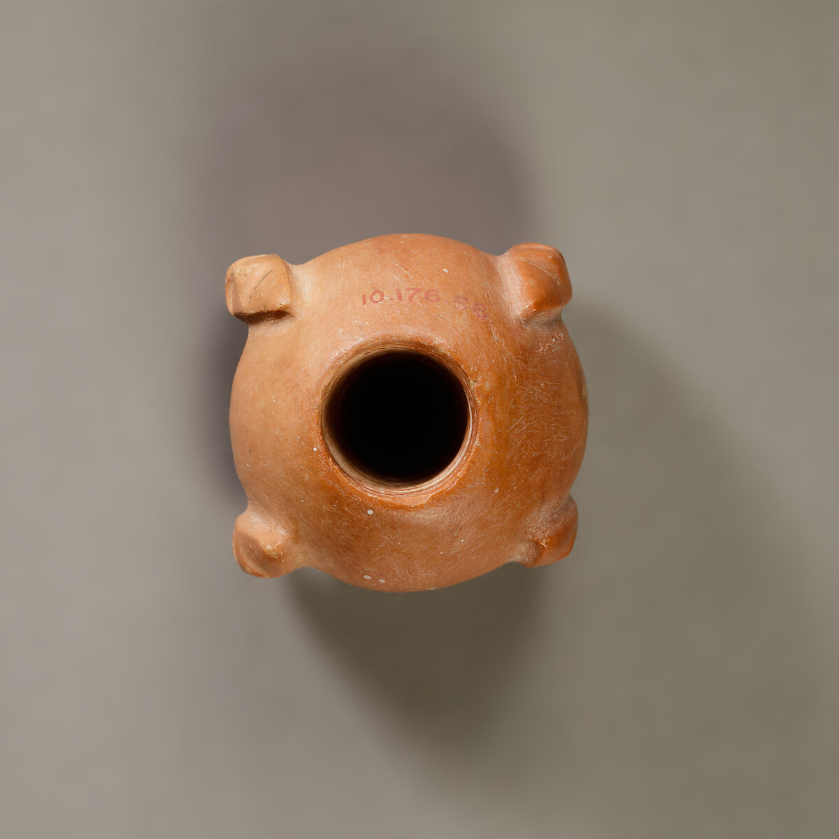 Piriform macehead with male faces, Limestone (pink), organic material