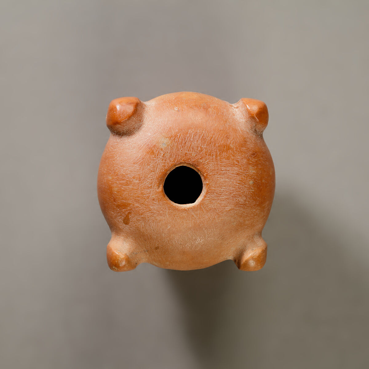 Piriform macehead with male faces, Limestone (pink), organic material