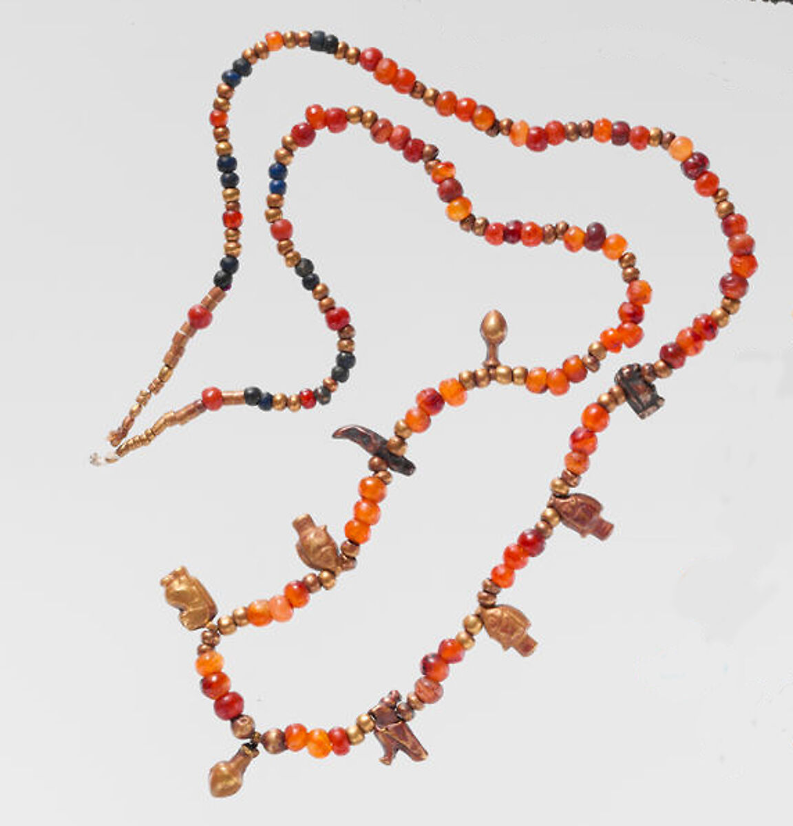 Necklace of ball beads and gold amulets, Gold over pitch, carnelian, lapis lazuli
Carnelian
Lapis-lazuli 