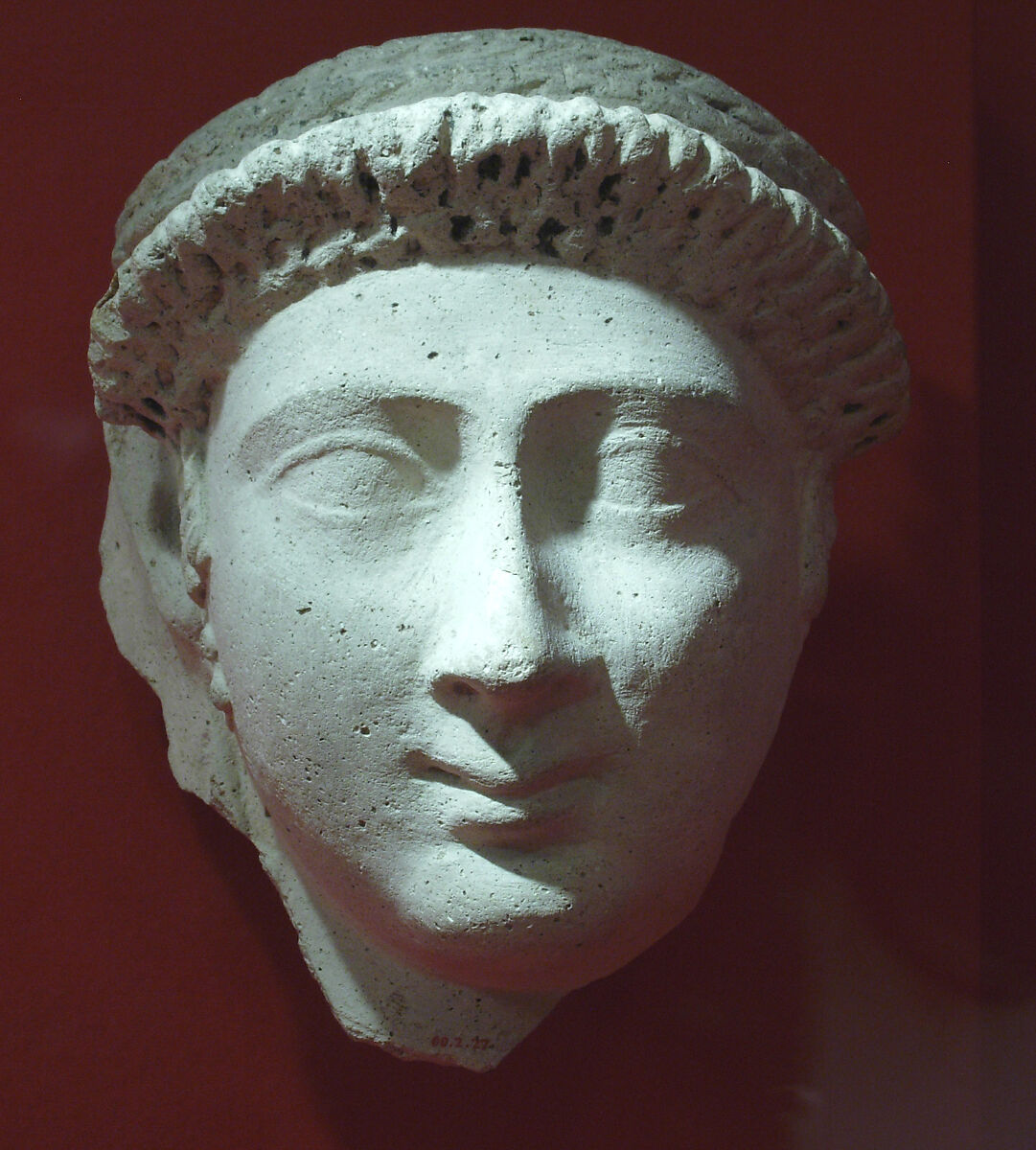 Mask of a woman with an ornate curled bang and loop earrings, Plaster, paint 