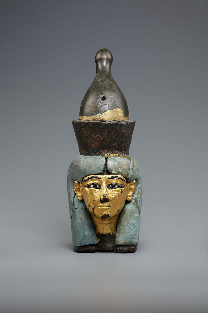 Attachment in the form of the head of a goddess wearing the double crown, Leaded bronze, gold and electrum sheet on crown, Egyptian blue and glass inlays 