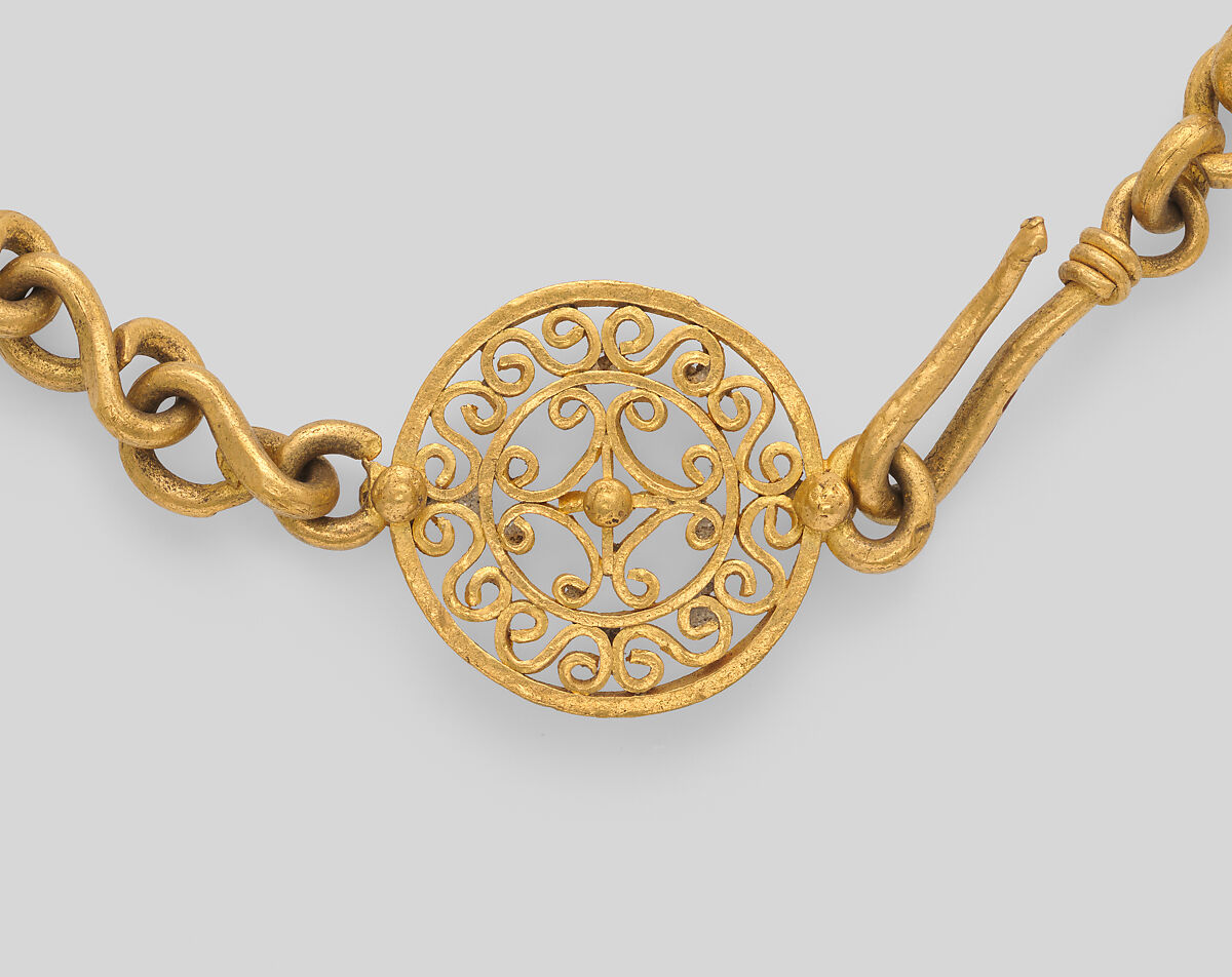 Necklace with ornate clasp ornament and a small drop pendant, gold