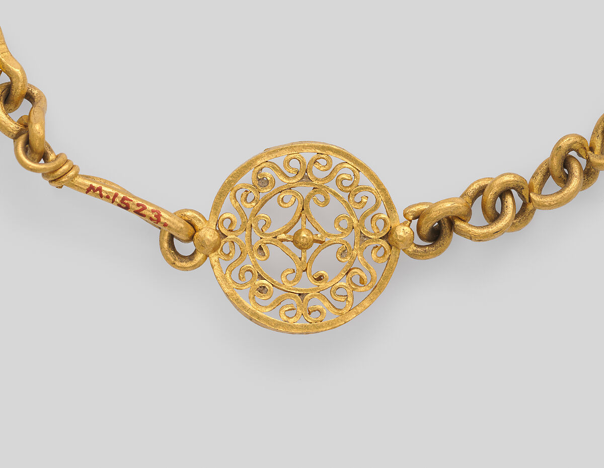 Necklace with ornate clasp ornament and a small drop pendant, gold