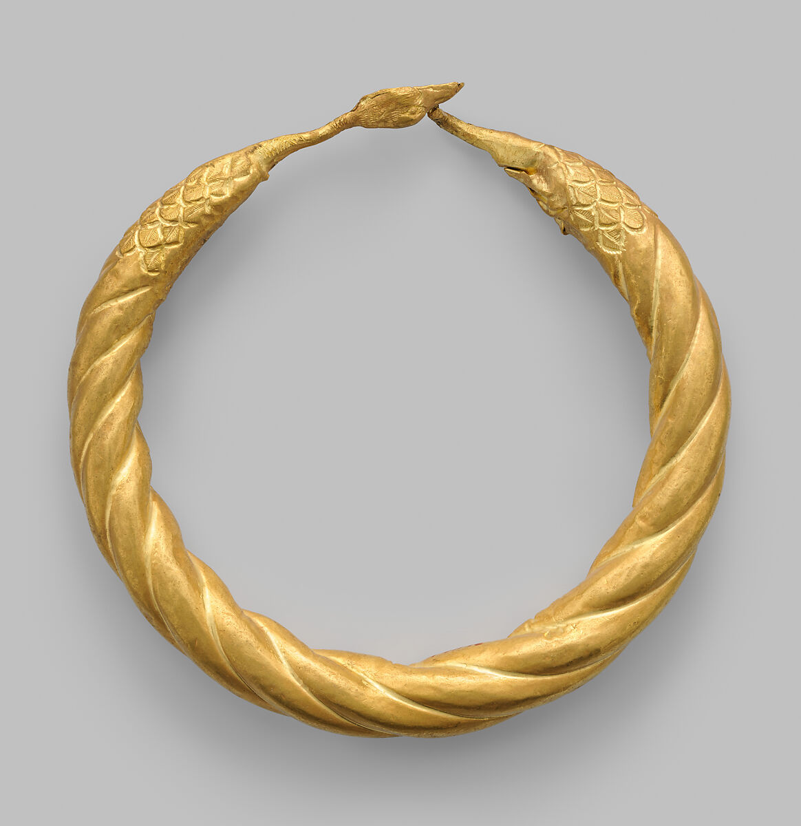 Spirally twisted tubular armlet with one goose-head terminal preserved, Gold