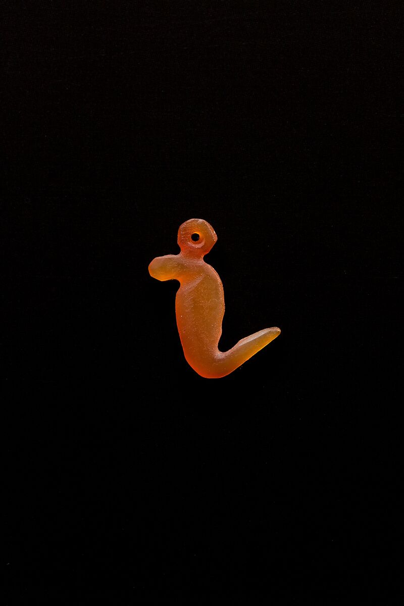 10 Amulets: 1 wedjat, 1 scarab, 3 djed pillars, 1 incised plaque, 1 uraeus, 2 wadj signs, and 1 cylindrical bead, Lapis lazuli, stone, carnelian, glass