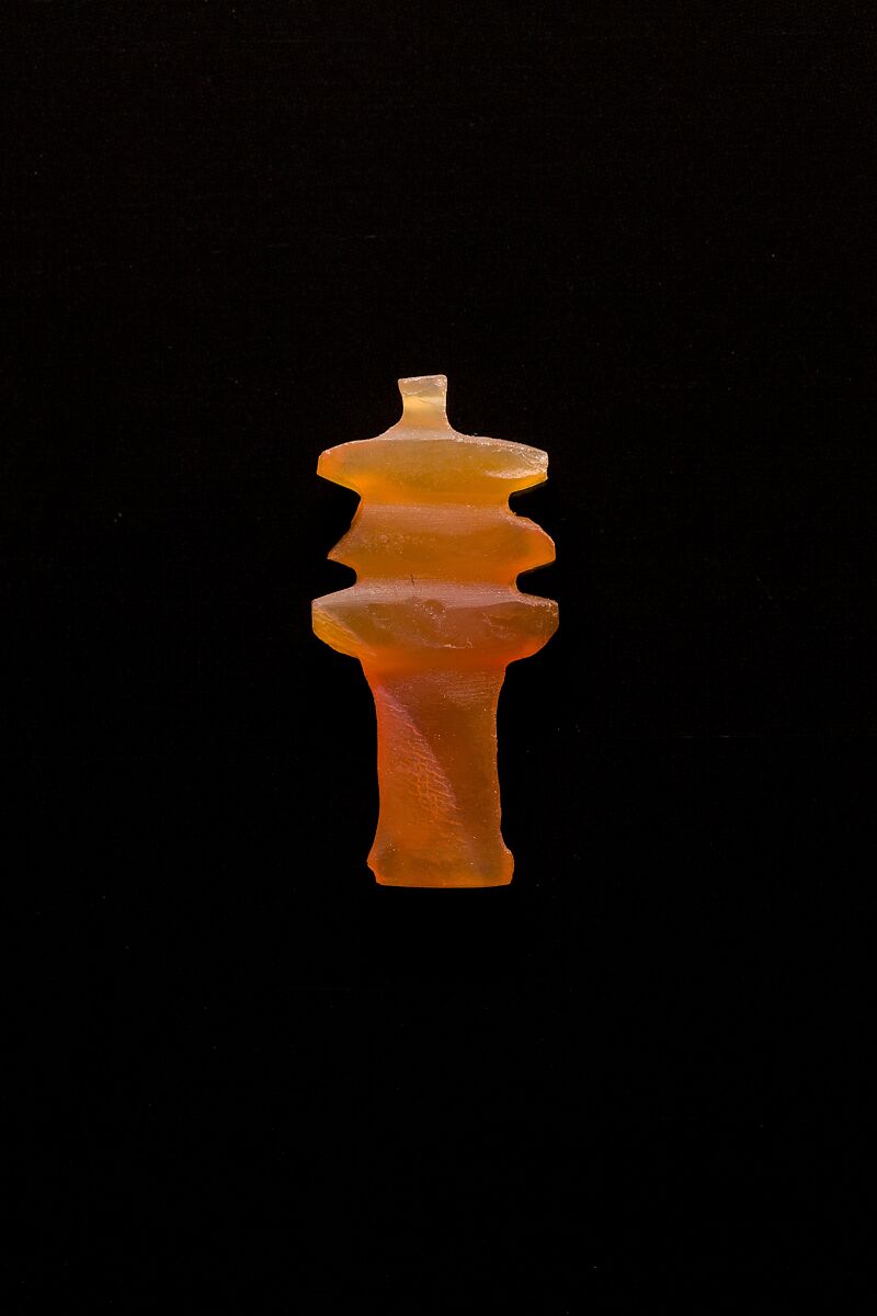 10 Amulets: 1 wedjat, 1 scarab, 3 djed pillars, 1 incised plaque, 1 uraeus, 2 wadj signs, and 1 cylindrical bead, Lapis lazuli, stone, carnelian, glass