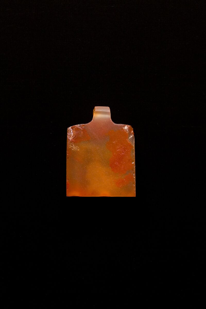 10 Amulets: 1 wedjat, 1 scarab, 3 djed pillars, 1 incised plaque, 1 uraeus, 2 wadj signs, and 1 cylindrical bead, Lapis lazuli, stone, carnelian, glass