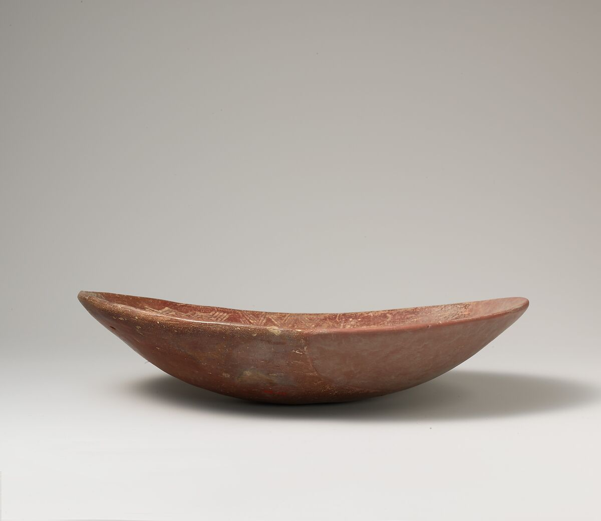 A shallow white cross-lined ware bowl illustrating a man on a boat alongside a hippo and crocodile, Pottery, paint