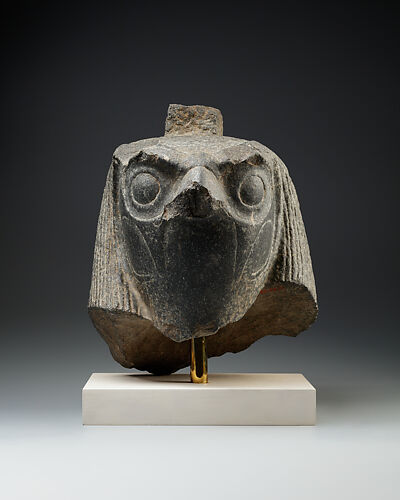 Falcon head with divine wig from a statue with an anthropomorphic body