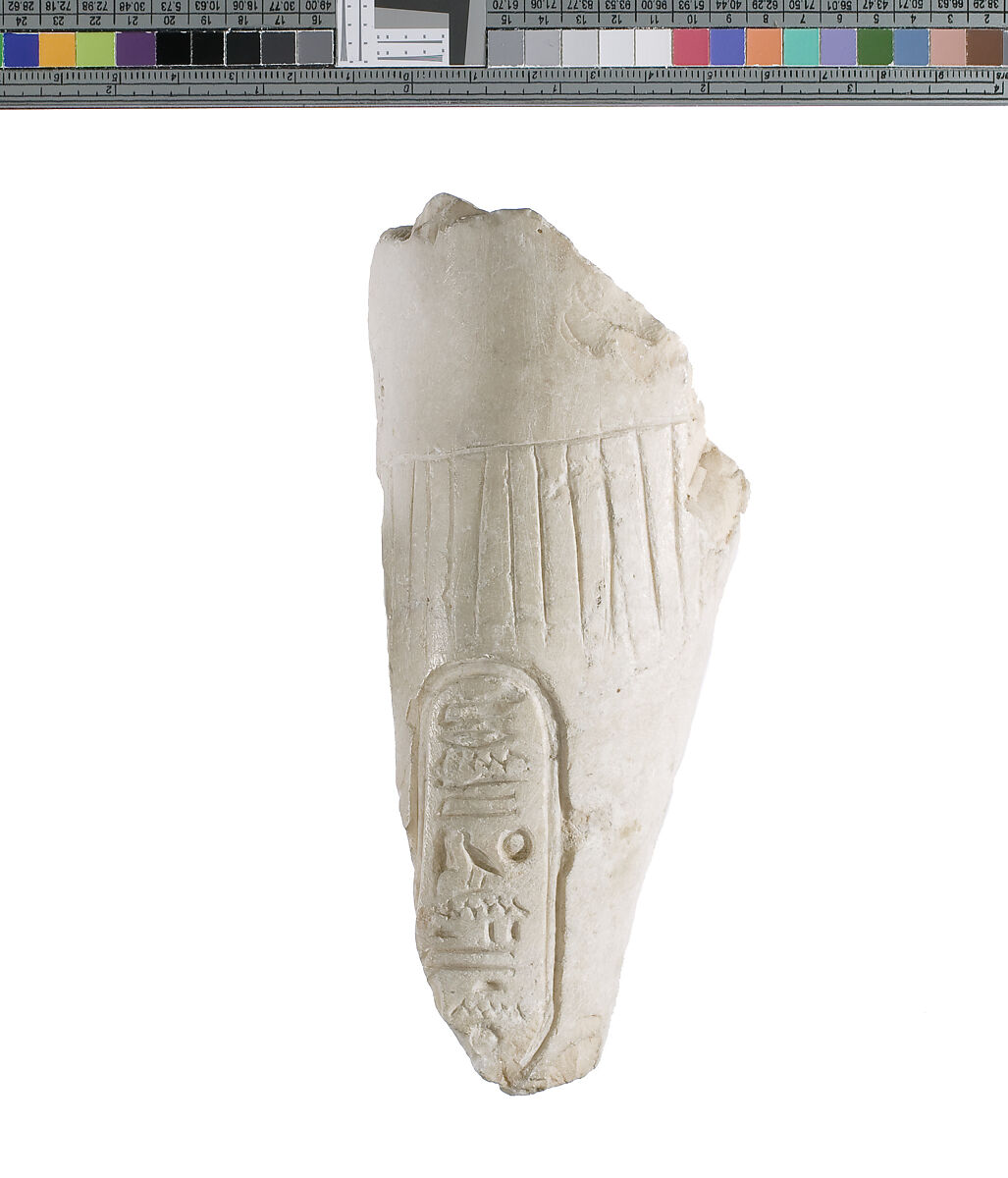 Left forearm with garment fringe, pleating and Aten cartouche, Indurated limestone