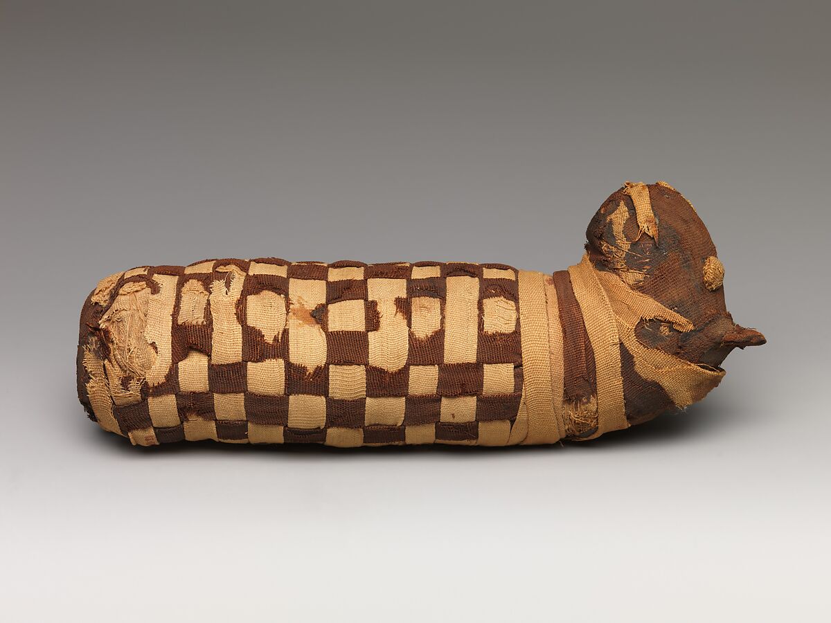 Sacred animal mummy containing dog bones, Dyed and undyed linen, animal remains, mummification materials