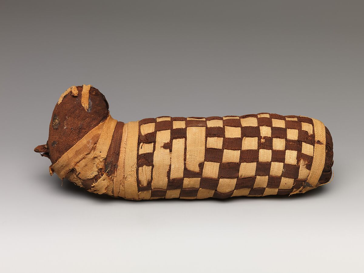 Sacred animal mummy containing dog bones, Dyed and undyed linen, animal remains, mummification materials