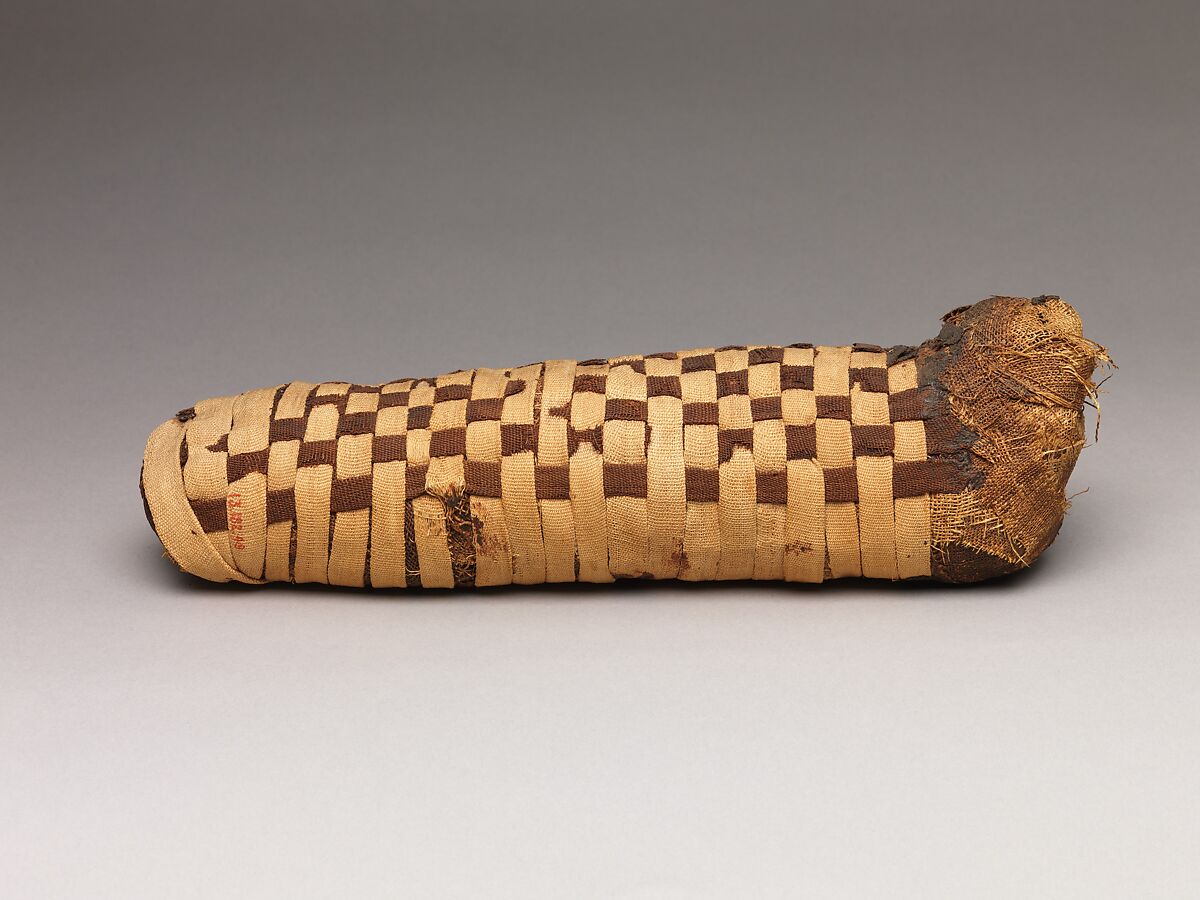 Sacred animal mummy of a canid, Dyed and undyed linen, animal remains, mummification materials