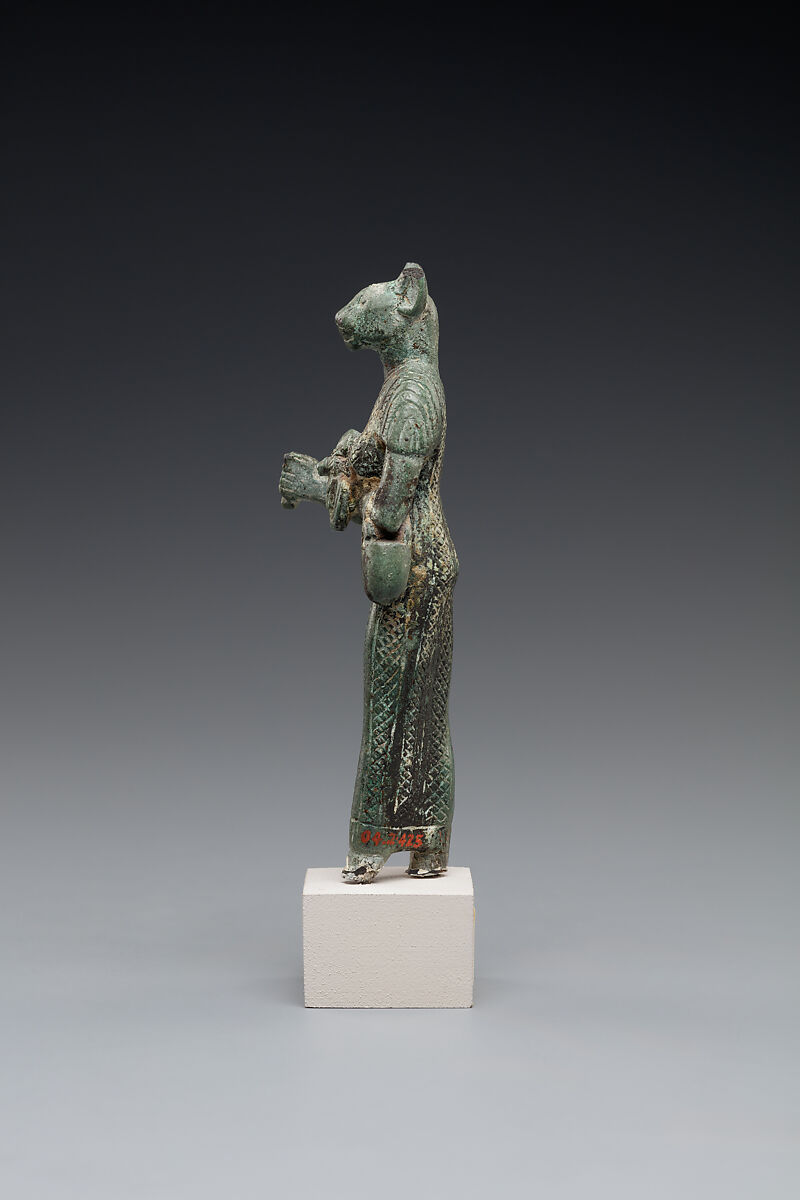 Bastet holding a lion-headed aegis, a sistrum (broken), and a basket, Bronze or copper alloy