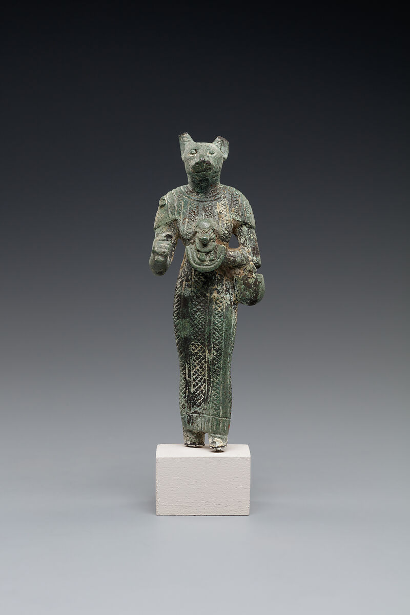 Bastet holding a lion-headed aegis, a sistrum (broken), and a basket, Bronze or copper alloy 