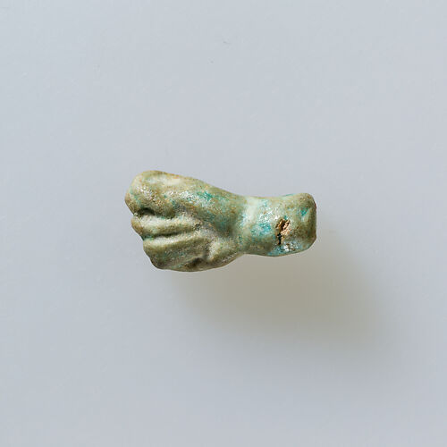 Amulet of fist with thumb thrust between first two fingers