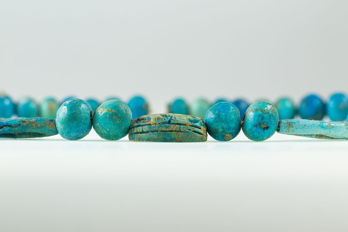 String of  ball beads, cowrie-styled beads, and a scarab, Faience, glazed steatite