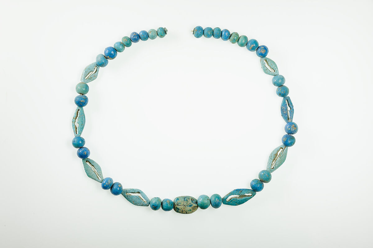 String of  ball beads, cowrie-styled beads, and a scarab, Faience, glazed steatite 