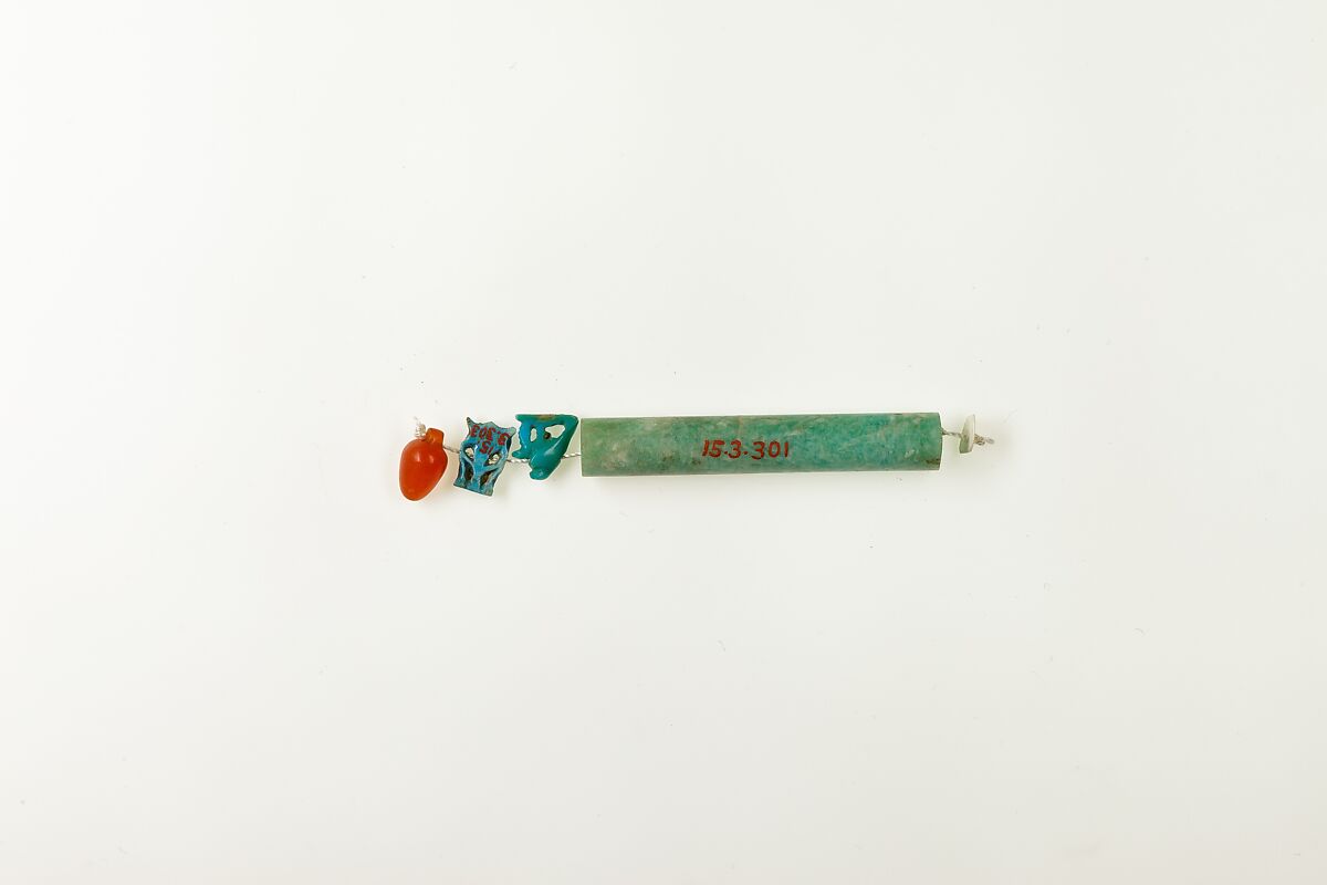 String of 3 amulets and 1 cylindrical bead, Green feldspar, beryl, faience, glazed steatite, and carnelian 