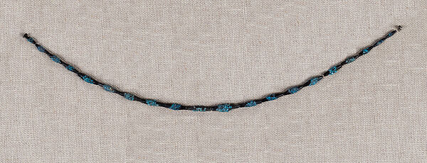 String of black faience beads with encrustations