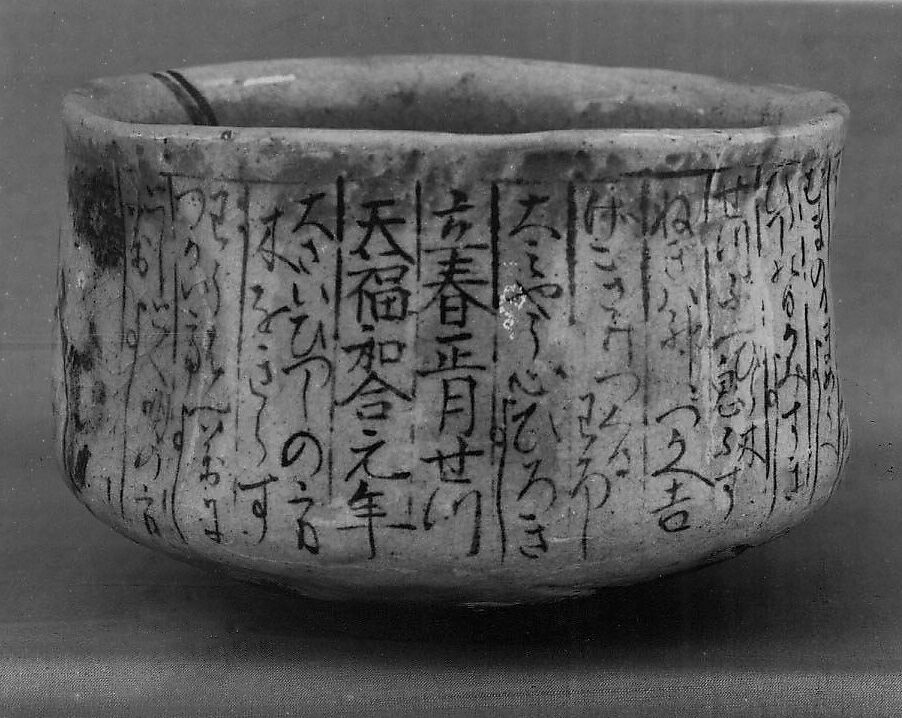 Teabowl, Clay covered with a transparent glaze and writing in black under the glaze (yellow Raku ware), Japan 