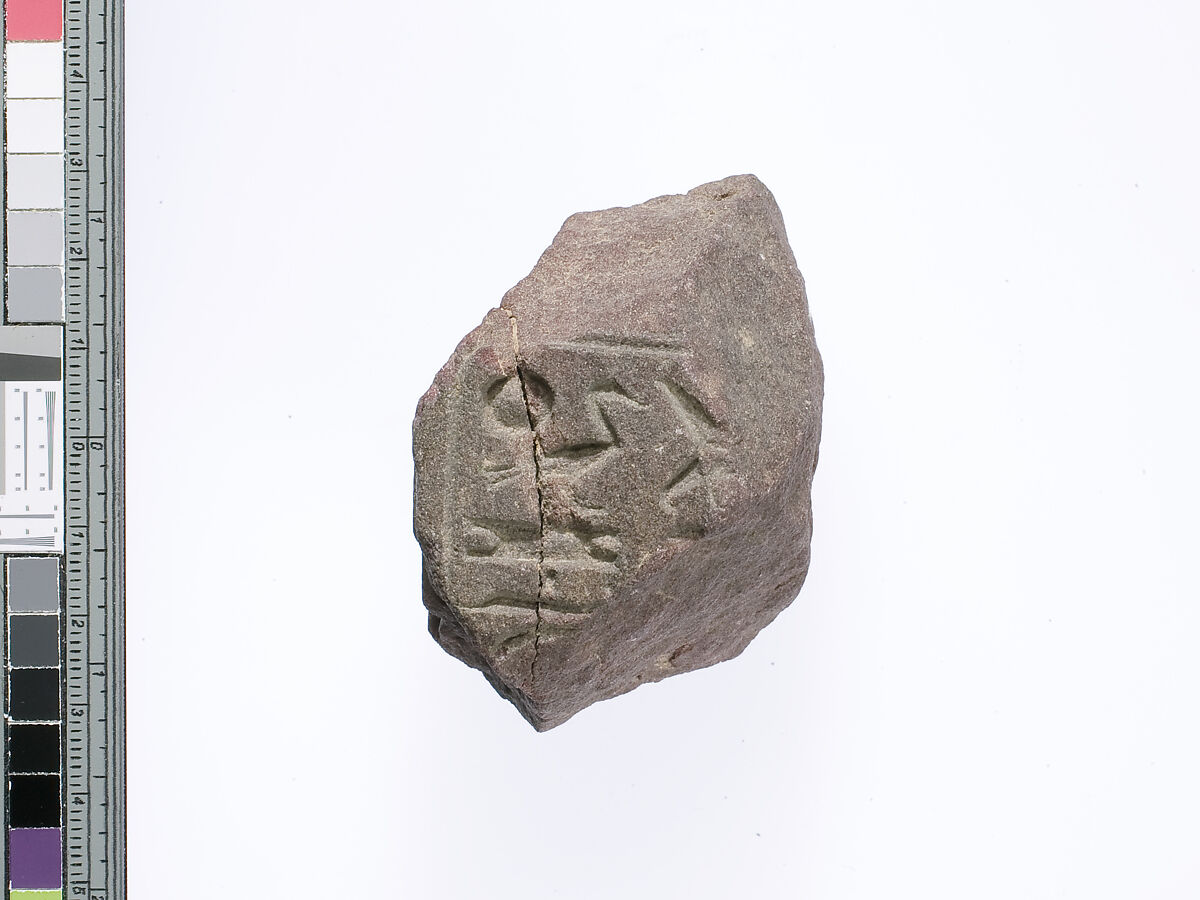 Part of a small block with parts of names of the Aten and Akhenaten preserved on two adjacent sides, Red quartzite