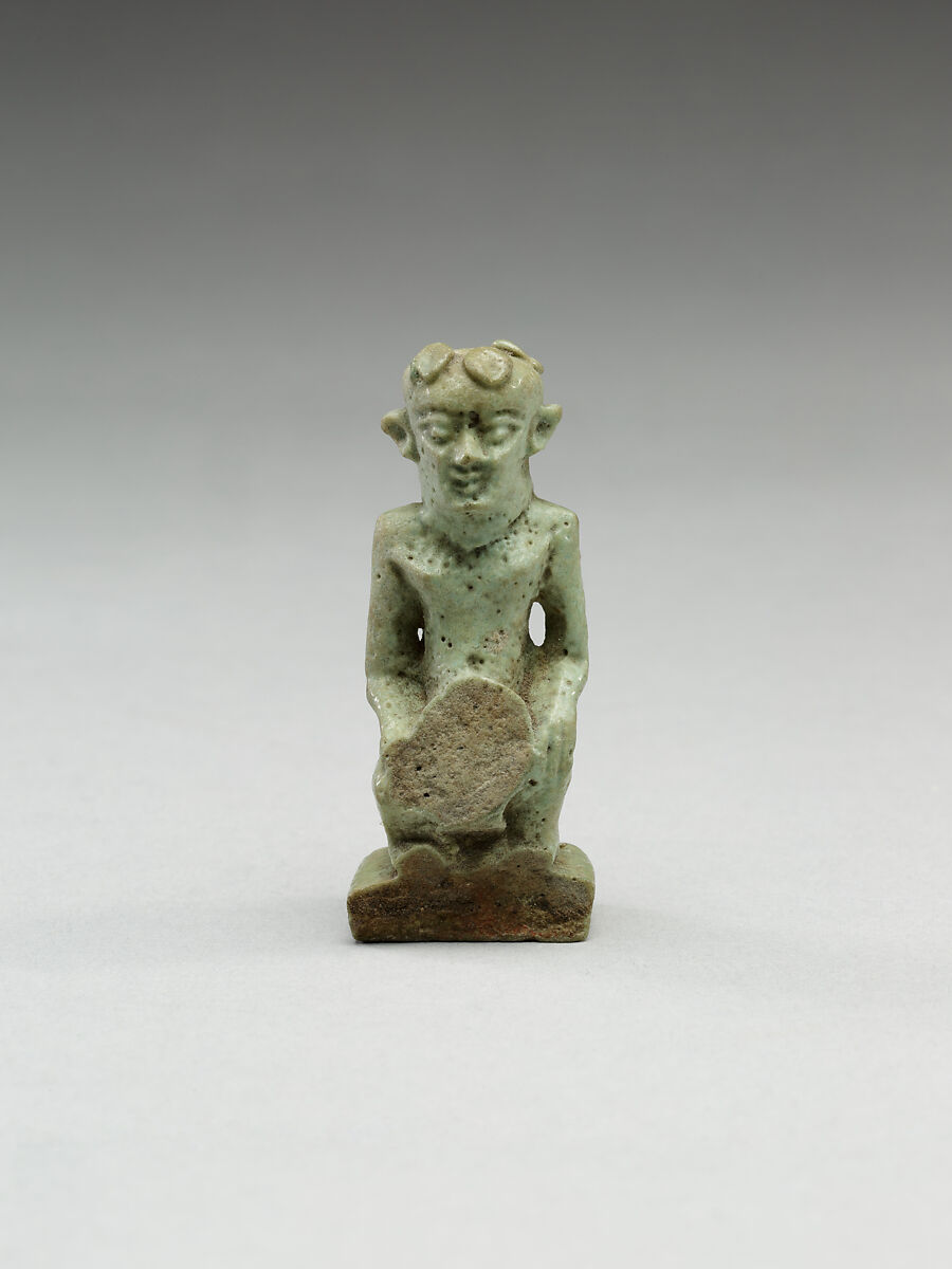 Nude crouching figure wearing a wreath, large phallus broken away, Faience