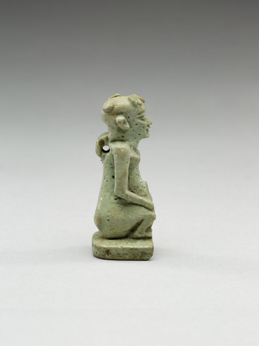 Nude crouching figure wearing a wreath, large phallus broken away, Faience