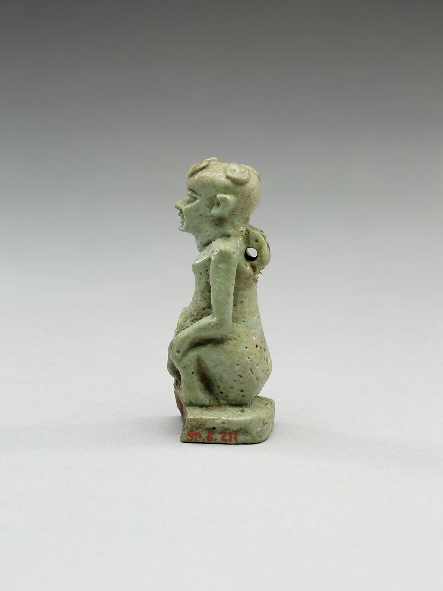 Nude crouching figure wearing a wreath, large phallus broken away, Faience