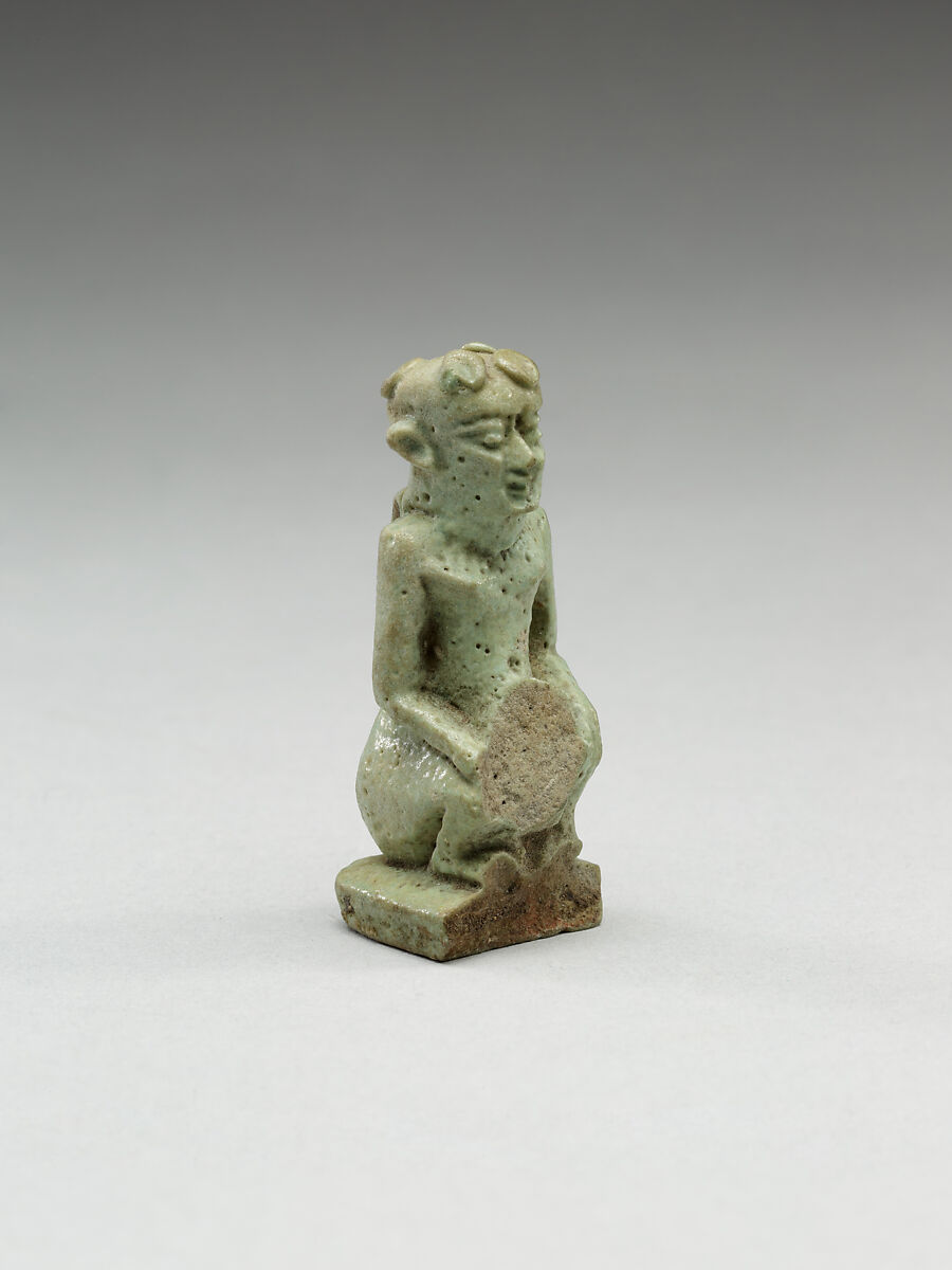 Nude crouching figure wearing a wreath, large phallus broken away, Faience