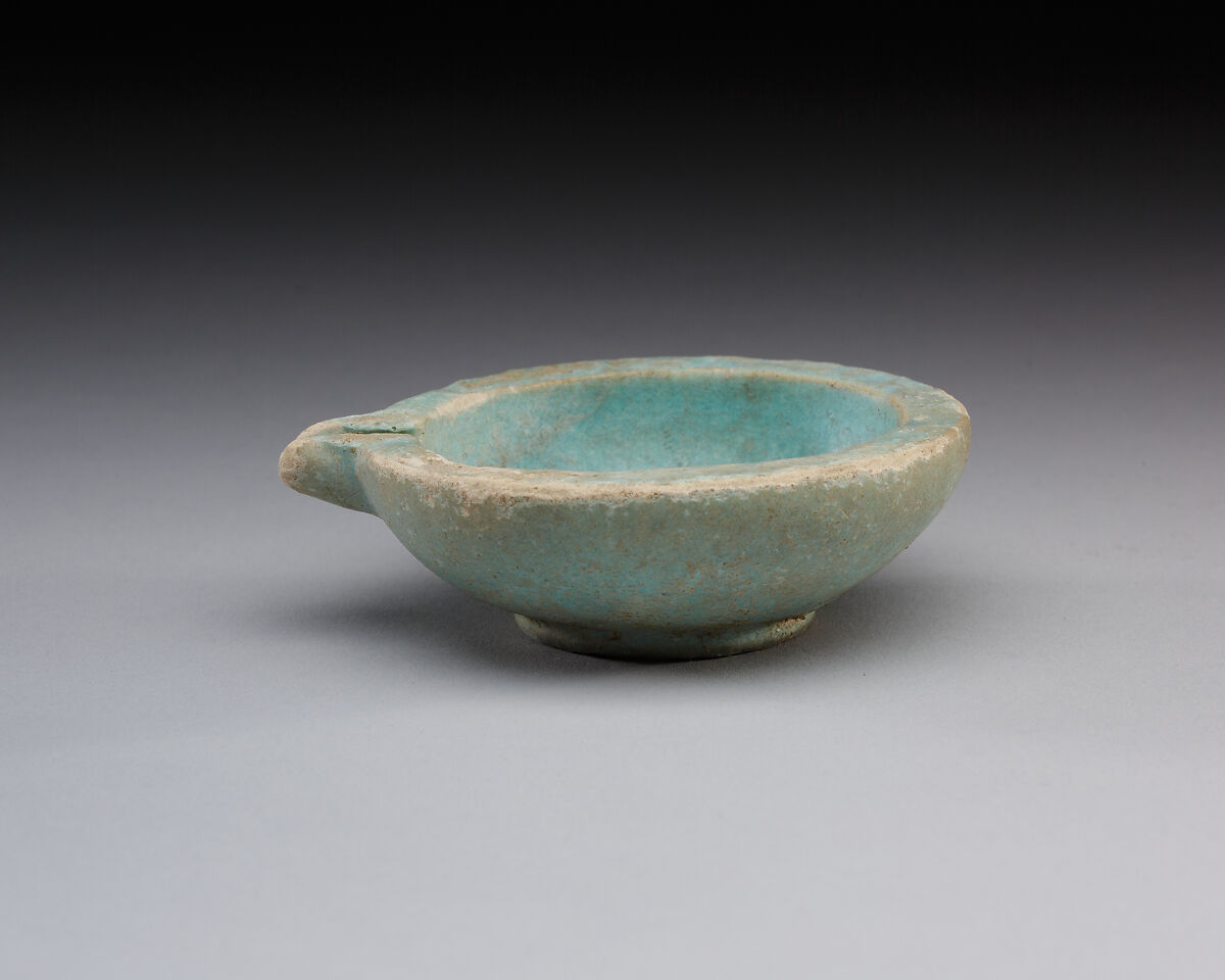 Spouted dish with rosette in the center, traces on the rim where two lions were attached, Faience