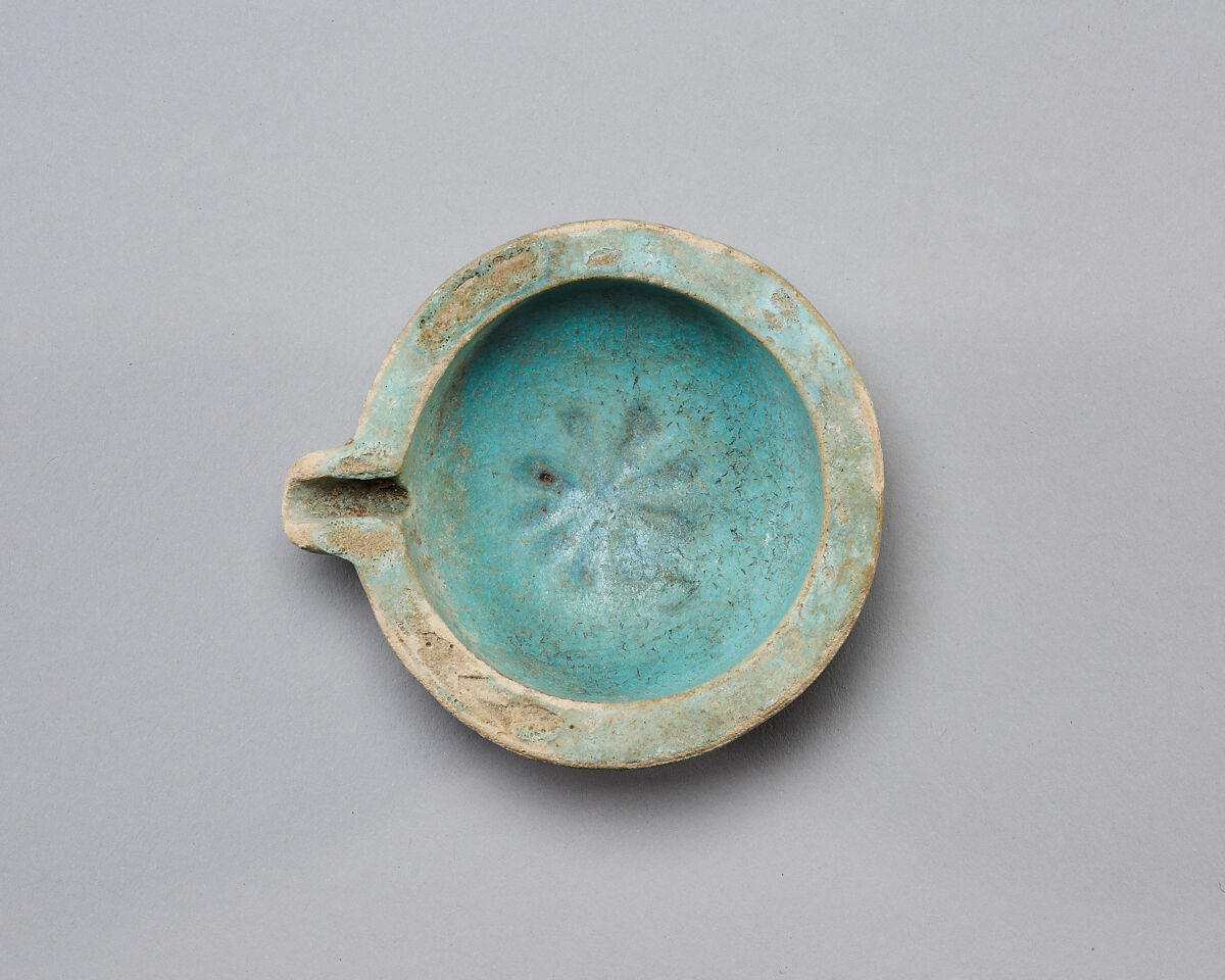 Spouted dish with rosette in the center, traces on the rim where two lions were attached, Faience