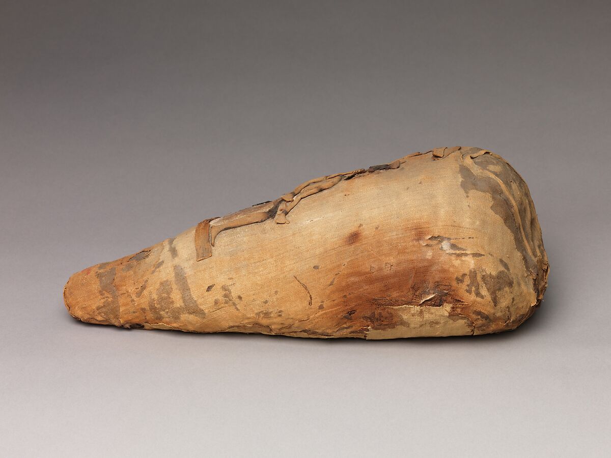 Package of disorganized animal remains adorned with a seated Thoth, Dyed and undyed linen, animal remains, mummification materials