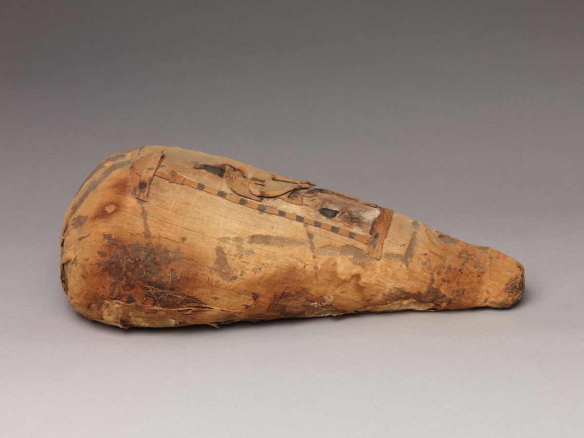 Package of disorganized animal remains adorned with a seated Thoth, Dyed and undyed linen, animal remains, mummification materials