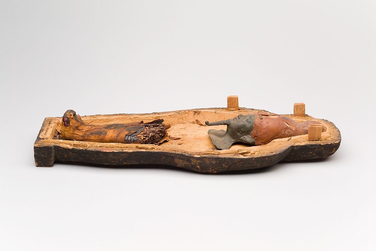 Coffin and corn mummy with Osiris mask, coffin: wood, paint 
mummy: grain, sand, clay and/or soil, resin, linen bandages 
mask: wax