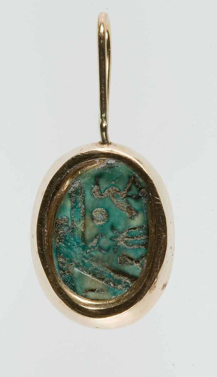 A modern pendant setting holding an inscribed scarab, Glazed steatite, gold 