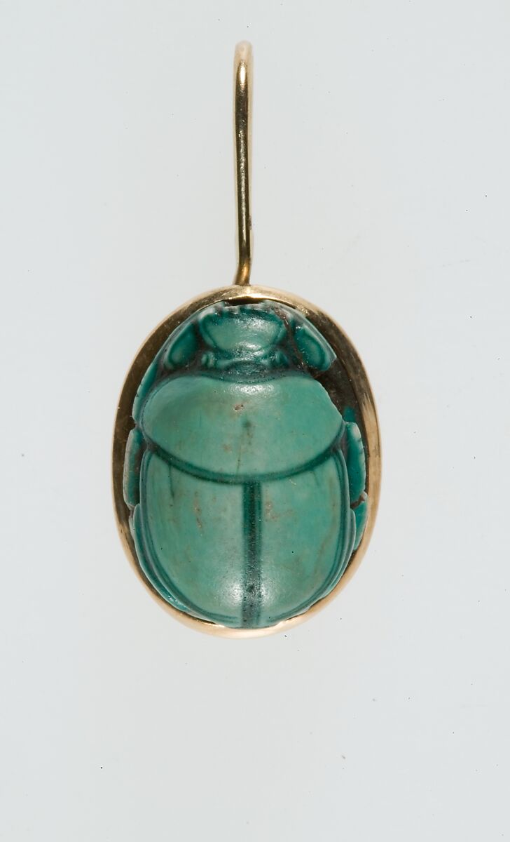 A modern pendant setting holding an inscribed scarab, Glazed steatite, gold