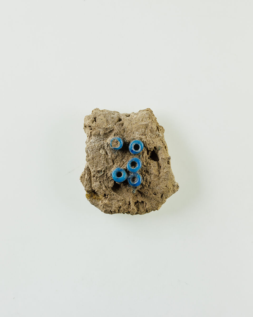 Fragment of clay lump with imbedded ring beads, Low-fired whitish clay, faience 