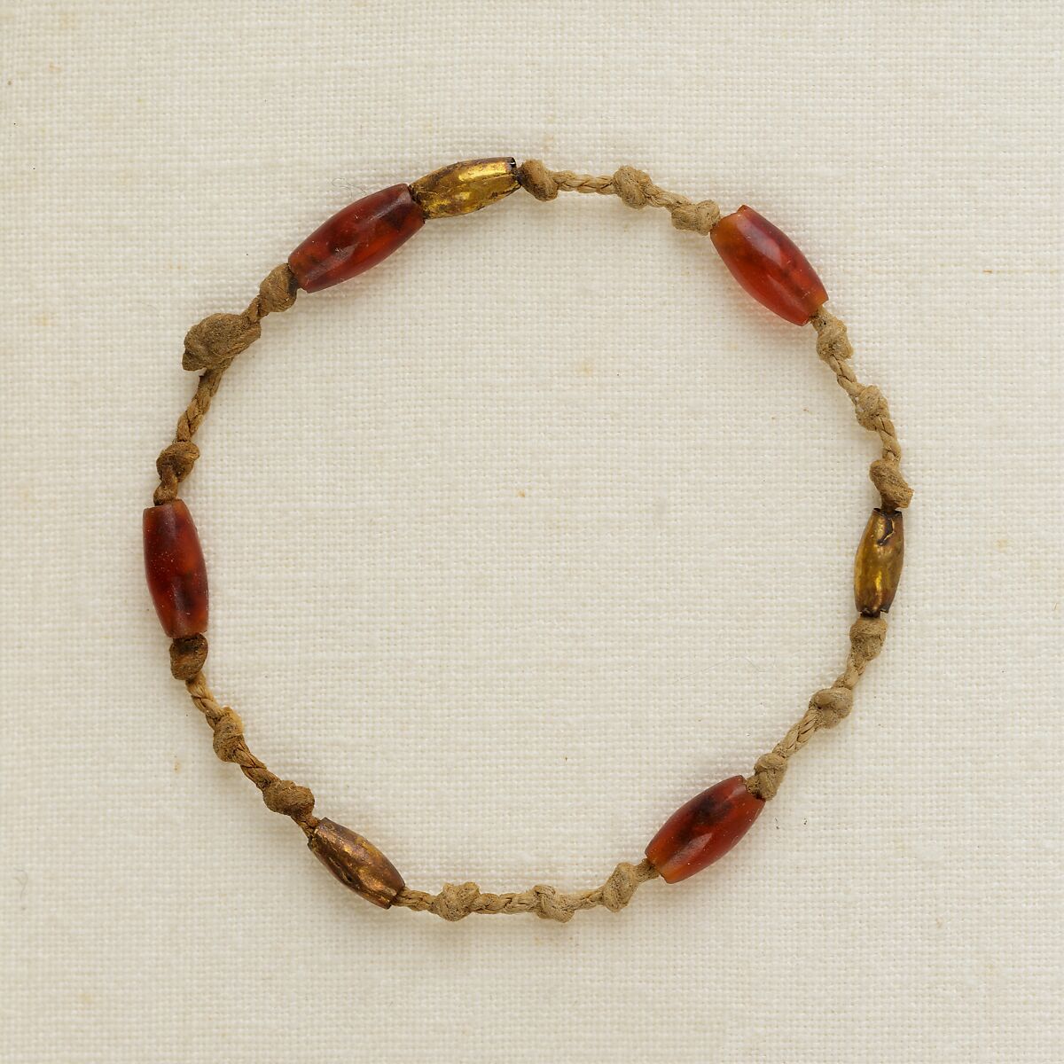 Bracelet of knots and barrel beads, Linen, gold, carnelian 