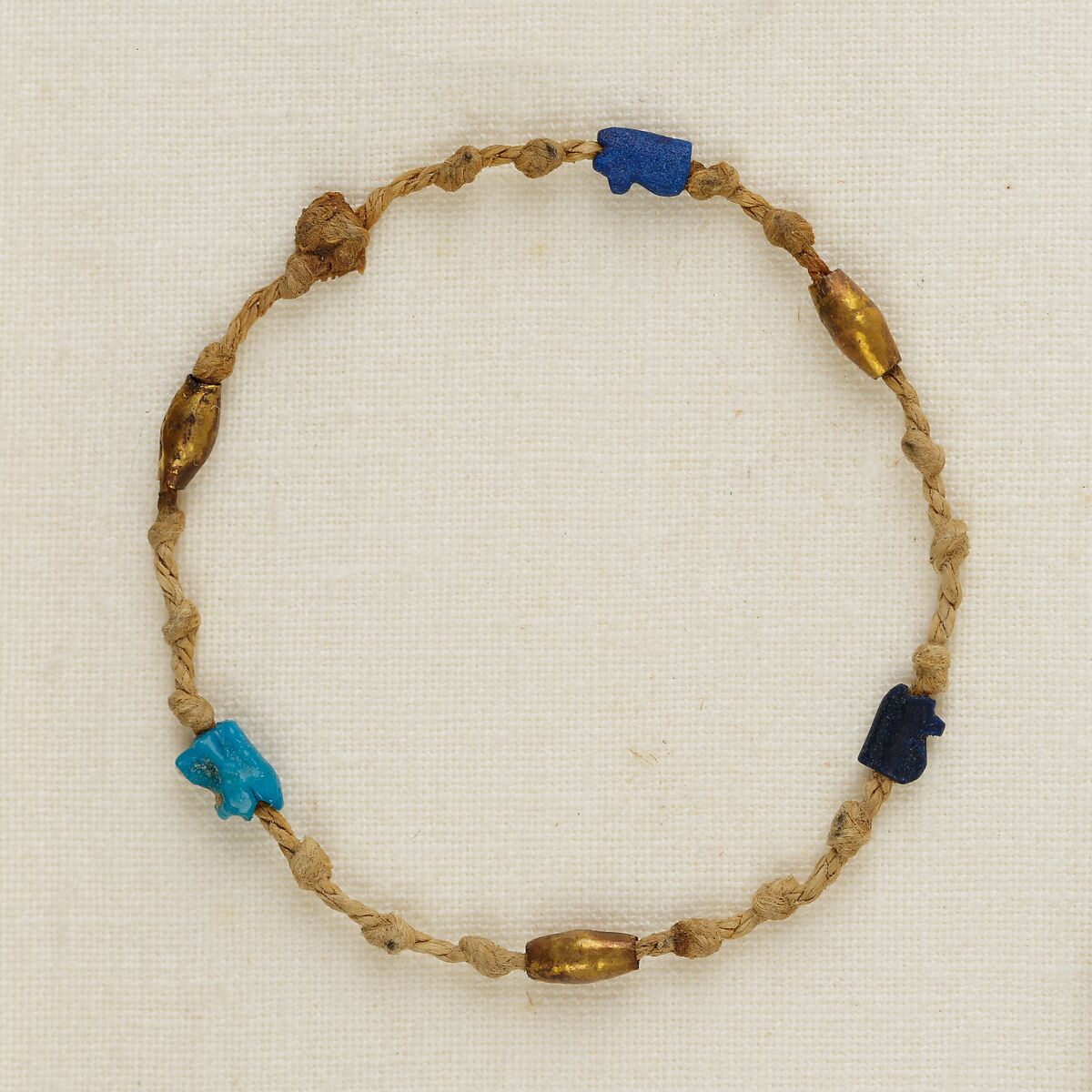 Bracelet with wedjat eye amulets and barrel beads, Linen, gold, glass, faience 
