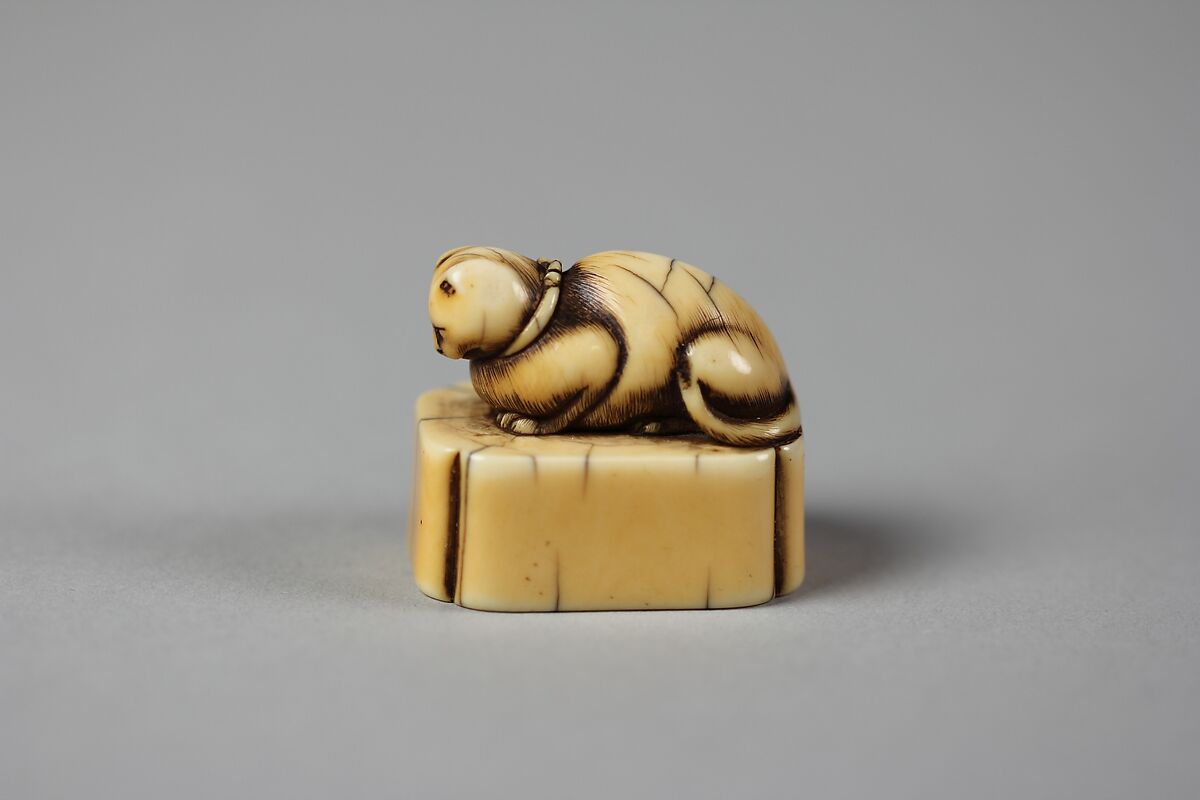 Netsuke of Cat on a Seal-Shaped Base, Ivory; slight brown stain, Japan 