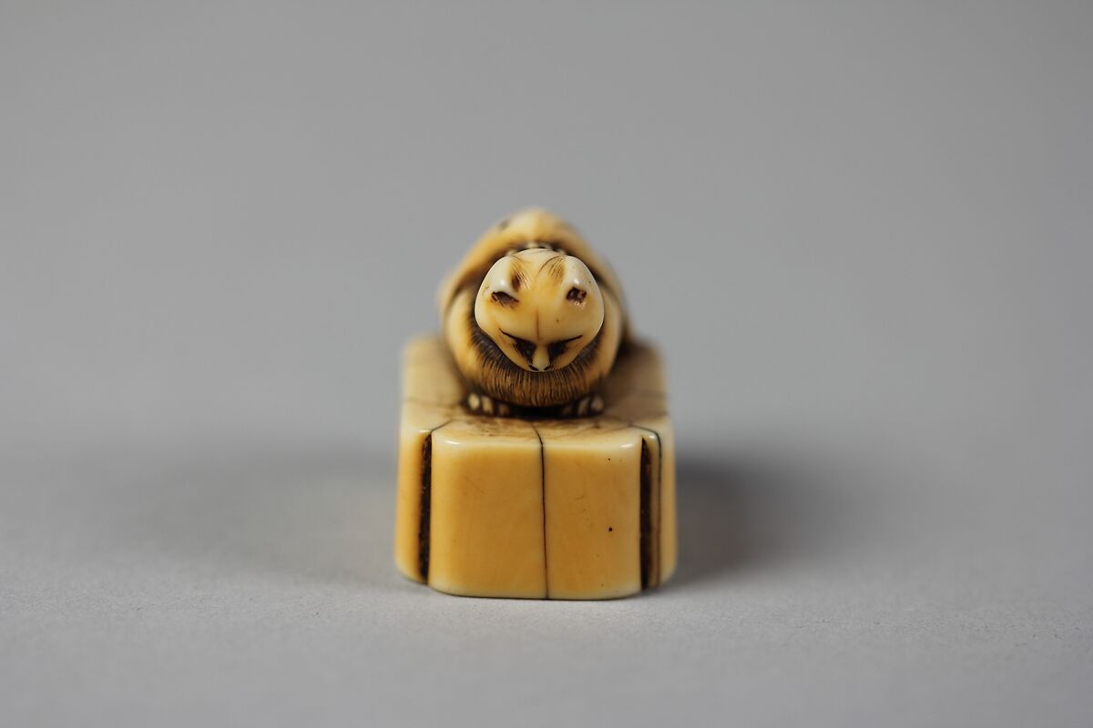 Netsuke of Cat on a Seal-Shaped Base, Ivory; slight brown stain, Japan