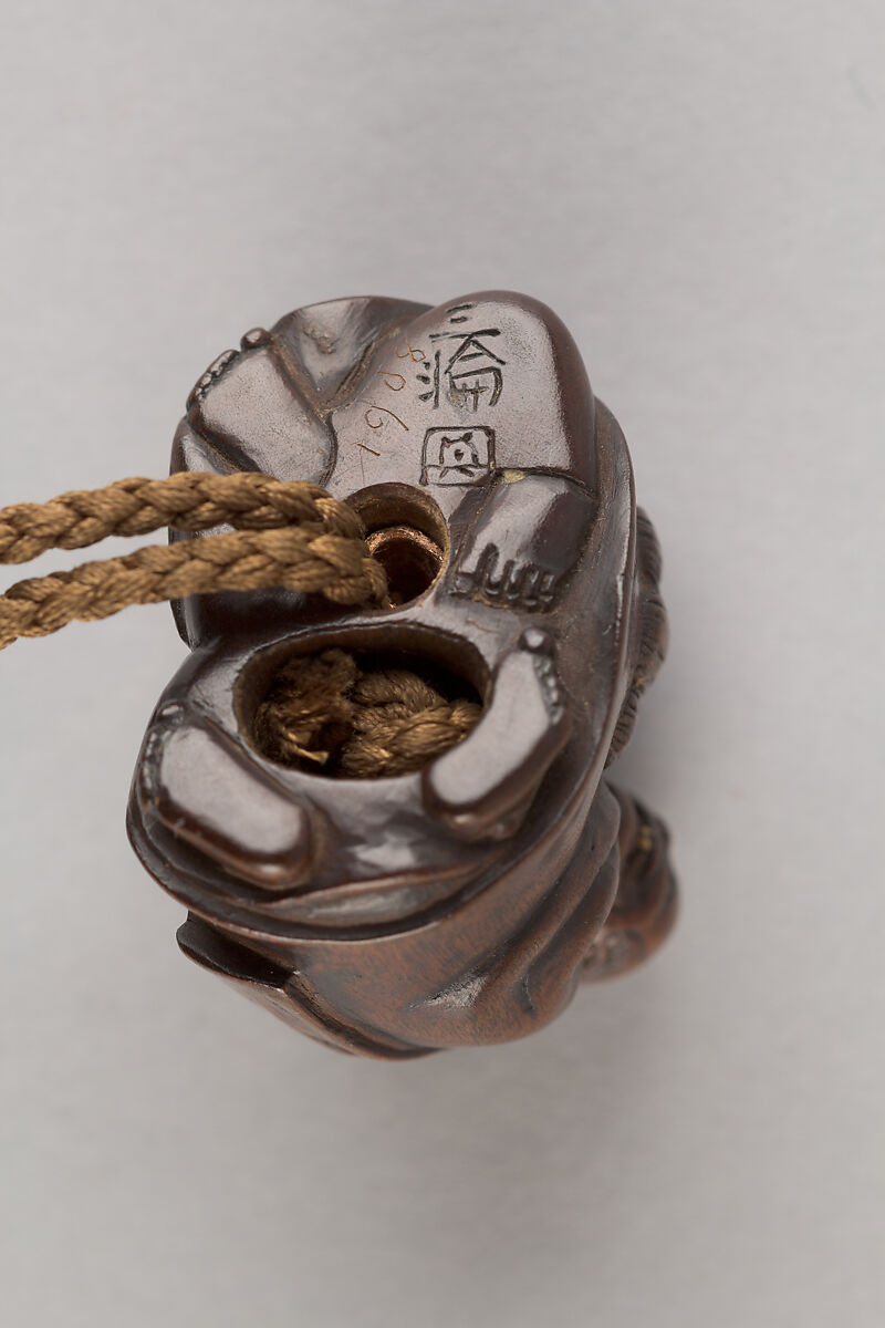 Inrō in the Shape of a Leather Tobacco Case (Tabakoire) with Flowering Plum, Attributed to Matsuda Sukenaga (Japanese, 1800–1871), Inrō: carved wood with lacquer imitating leather; gilded metal clasp; ojime: patinated metal bead; netsuke: Chinese boy (karako) with mask on shishi lion; carved wood, Japan