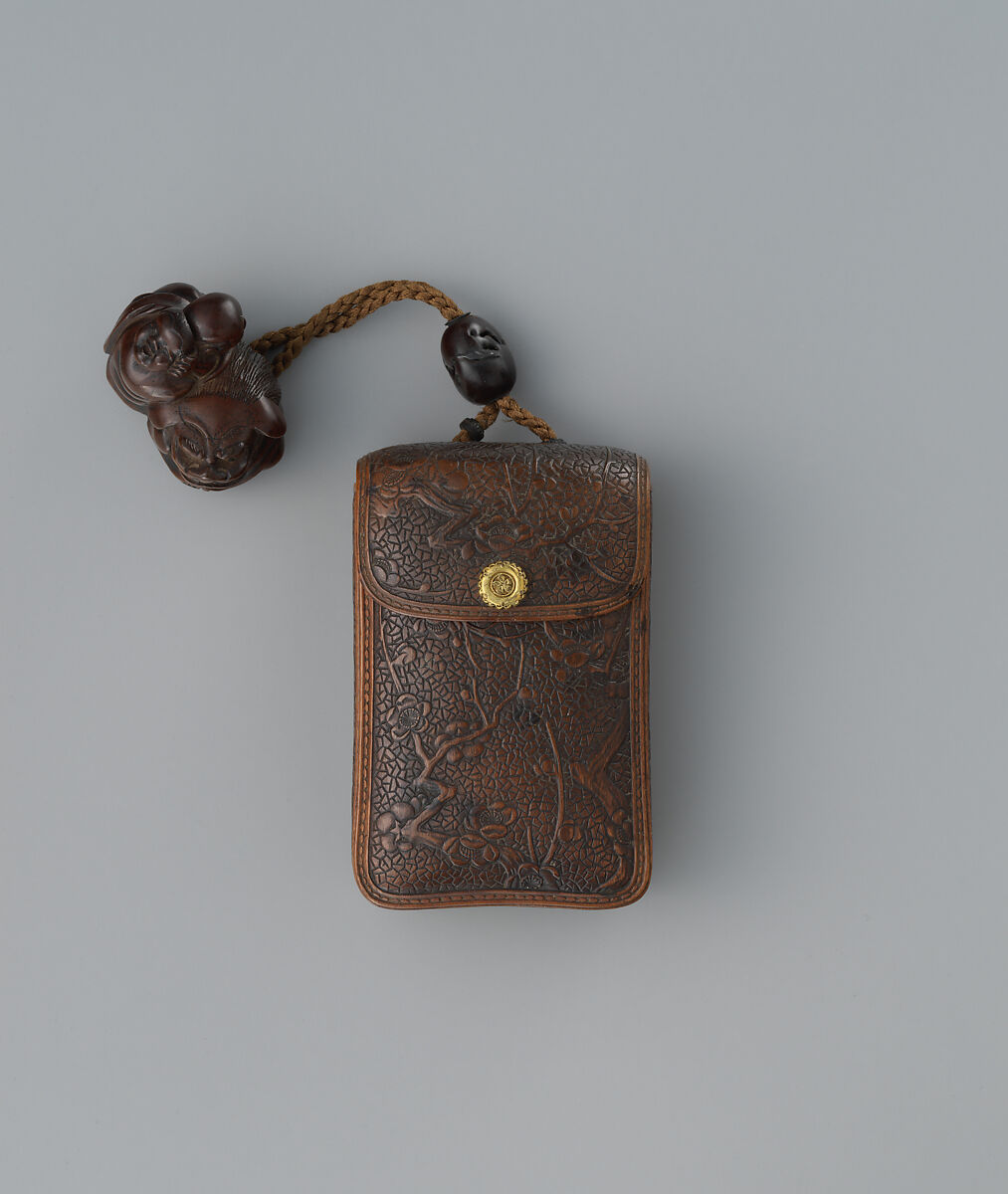 Inrō in the Shape of a Leather Tobacco Case (Tabakoire) with Flowering Plum, Attributed to Matsuda Sukenaga (Japanese, 1800–1871), Inrō: carved wood with lacquer imitating leather; gilded metal clasp; ojime: patinated metal bead; netsuke: Chinese boy (karako) with mask on shishi lion; carved wood, Japan