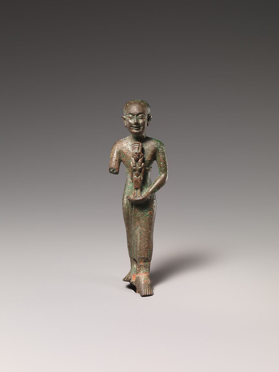 Standing man holding statuette of Nebethetepet or Nehemetaui, cupreous metal 